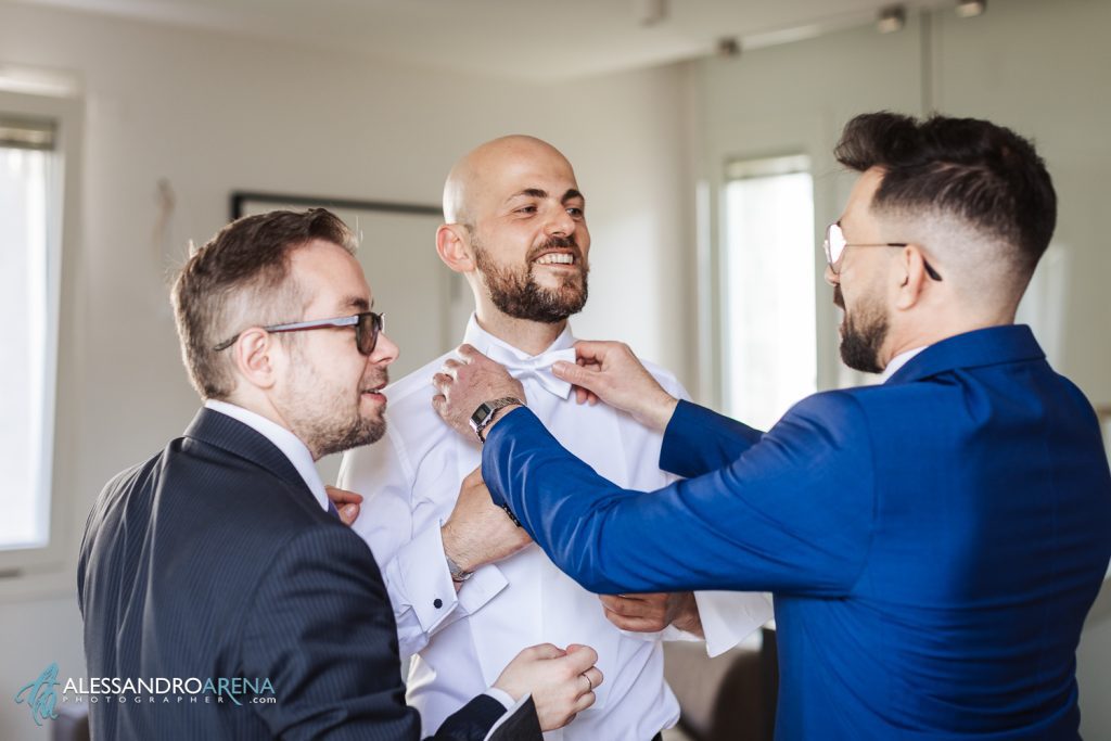 Gli amici aiutano lo sposo con il papillon