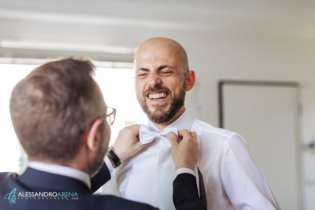 Gli amici aiutano lo sposo con il papillon