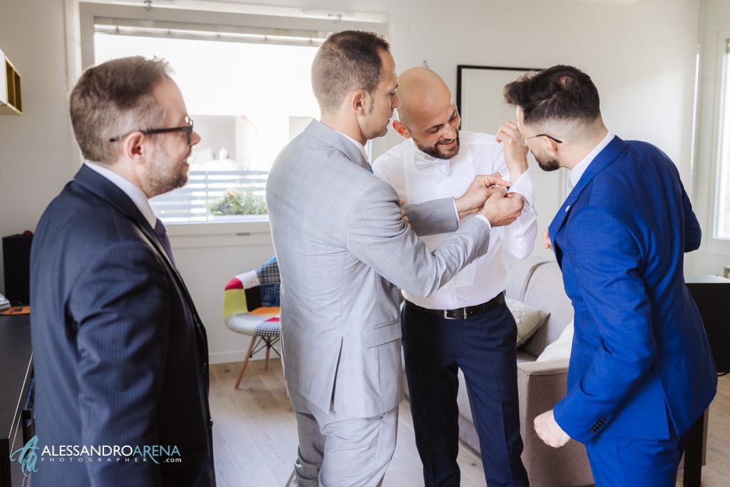 Gli amici aiutano lo sposo con i gemelli