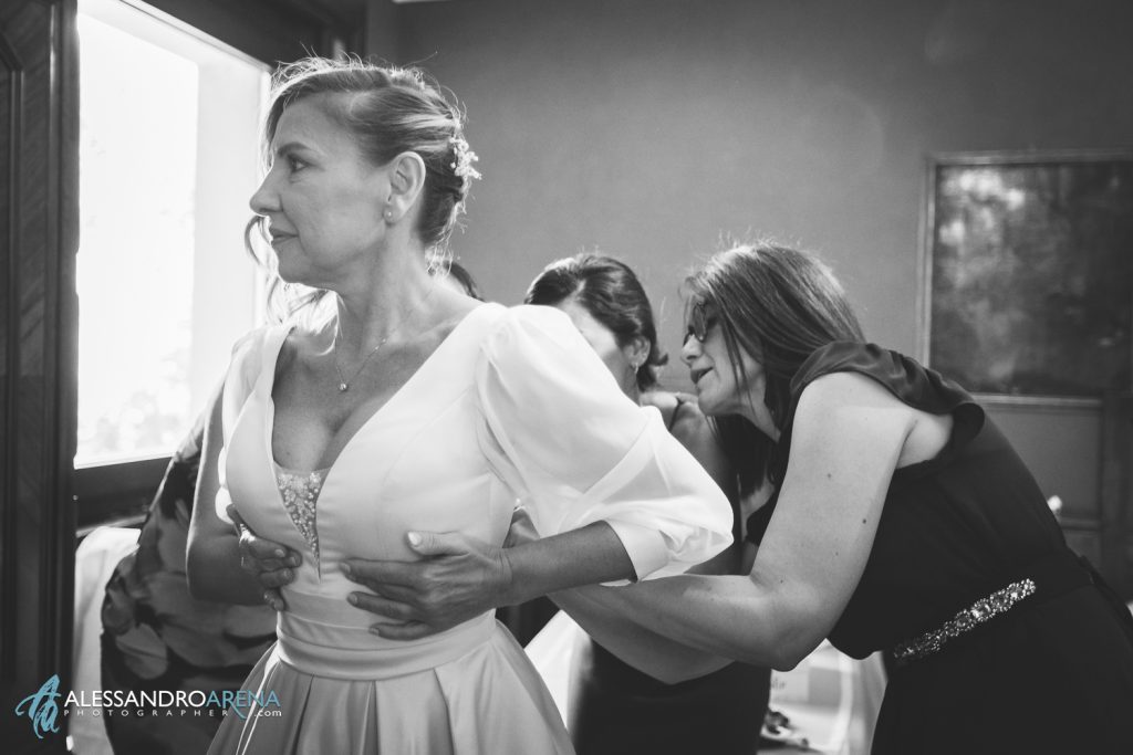 Le amiche aiutno la sposa a chiudere l'abito