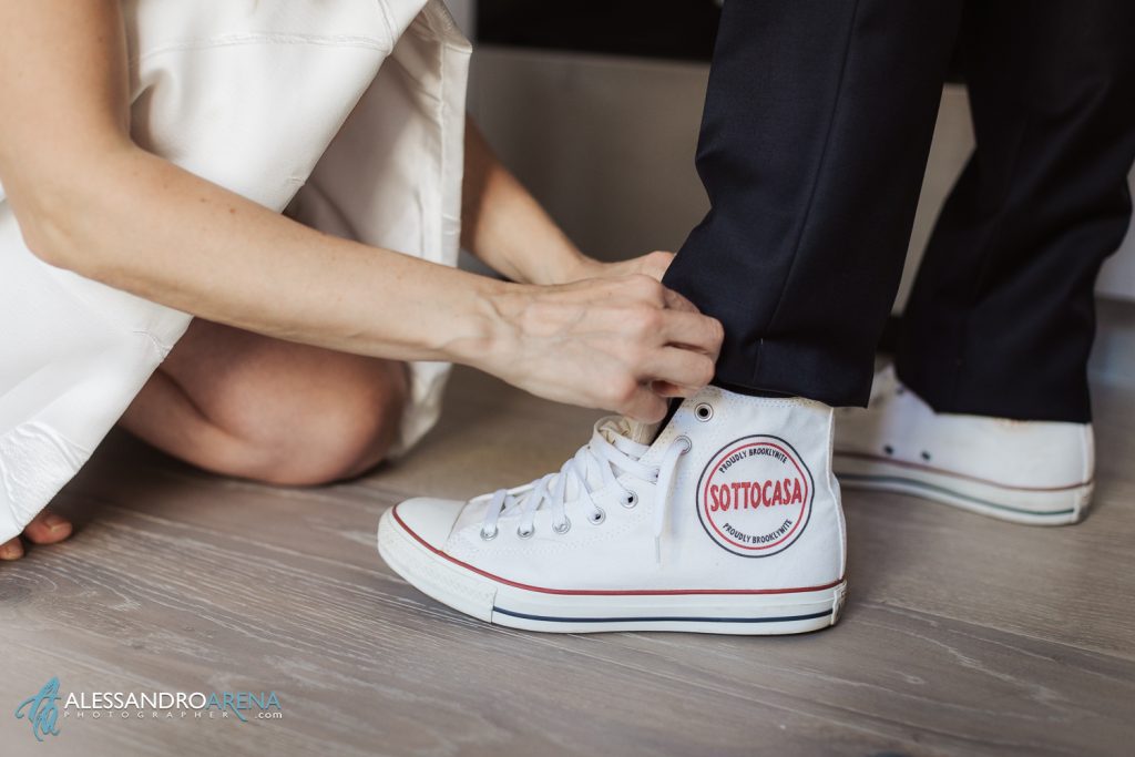 La sposa aiuta lo sposo ad indossare le scarpe