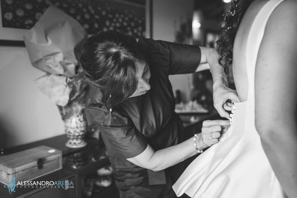 La mamma della sposa la aiuta a chiudere l'abito
