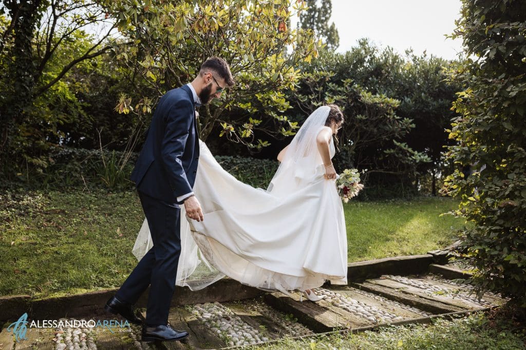Lo sposo sorregge lo strascico della sposa