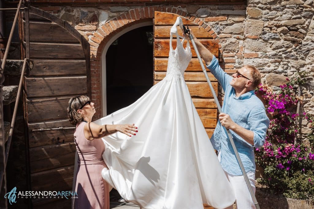 I genitori sistemano l'abito della sposa