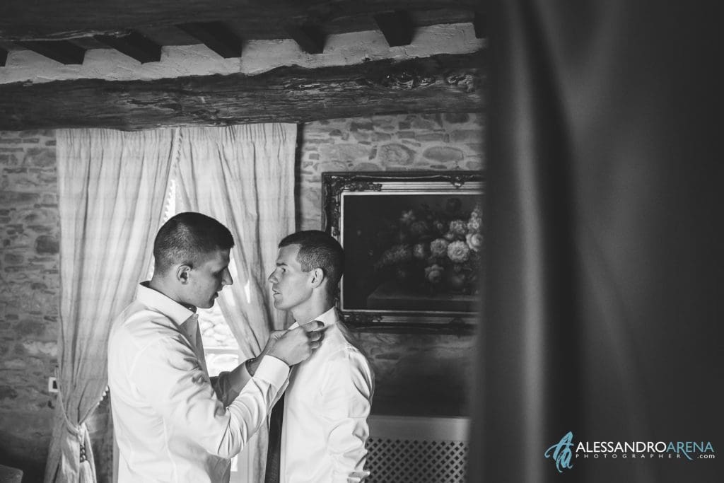 Il fratello aiuto lo sposo ad indossare la cravatta