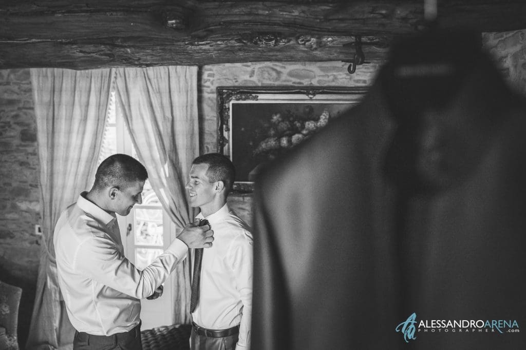 Il fratello aiuto lo sposo ad indossare la cravatta